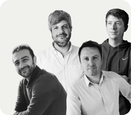 Quatre hommes souriants posant pour un webinaire, habillés de manière décontractée et formelle, sur fond neutre